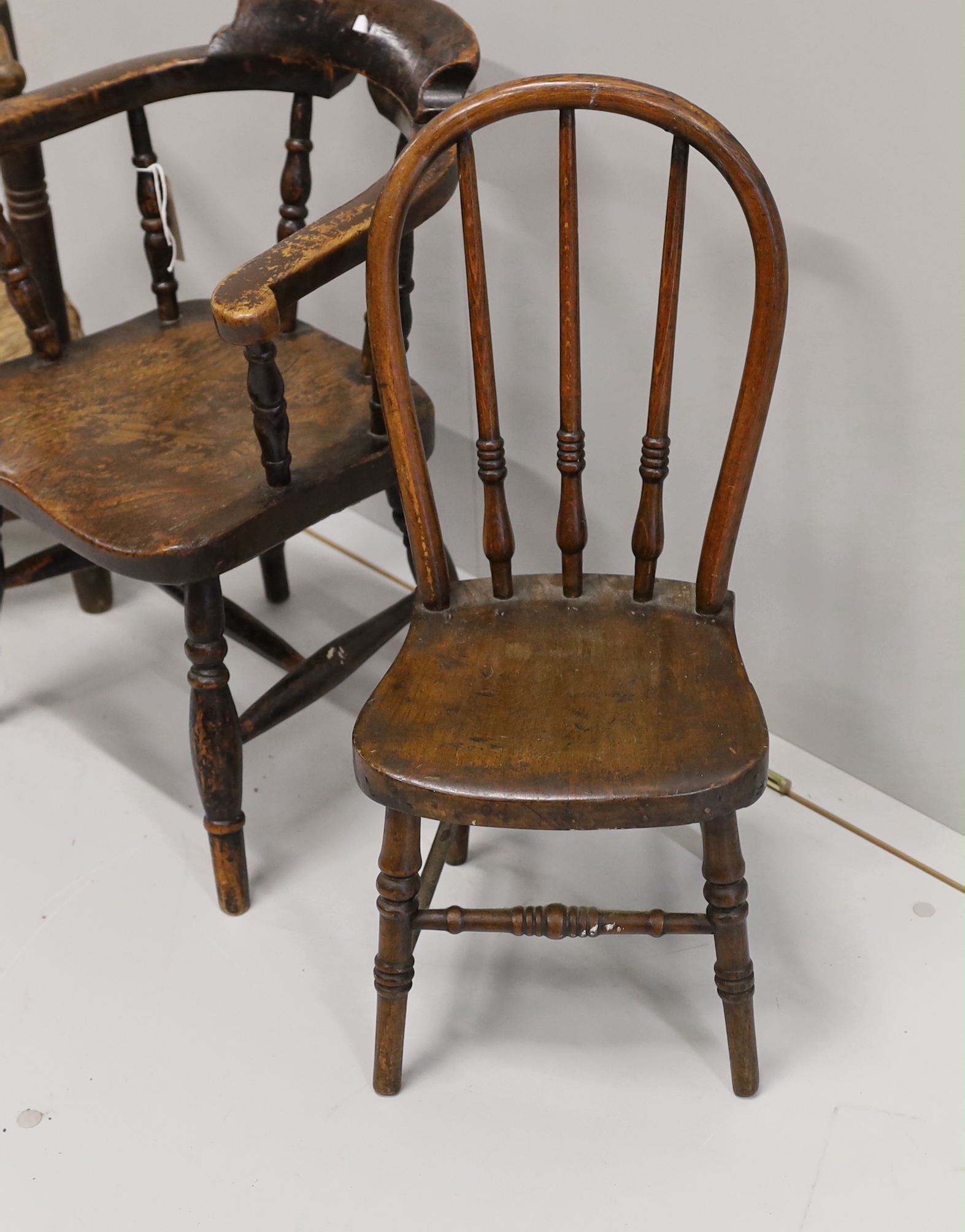 A child's Victorian elm and beech bow chair, a single chair and a rush seat chair